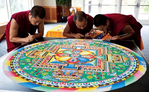 Monks working on a sand mandala. Source