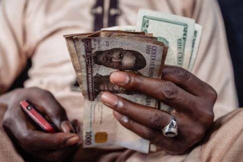街头货币交易商持有美元和尼日利亚奈拉；来源：彭博新闻