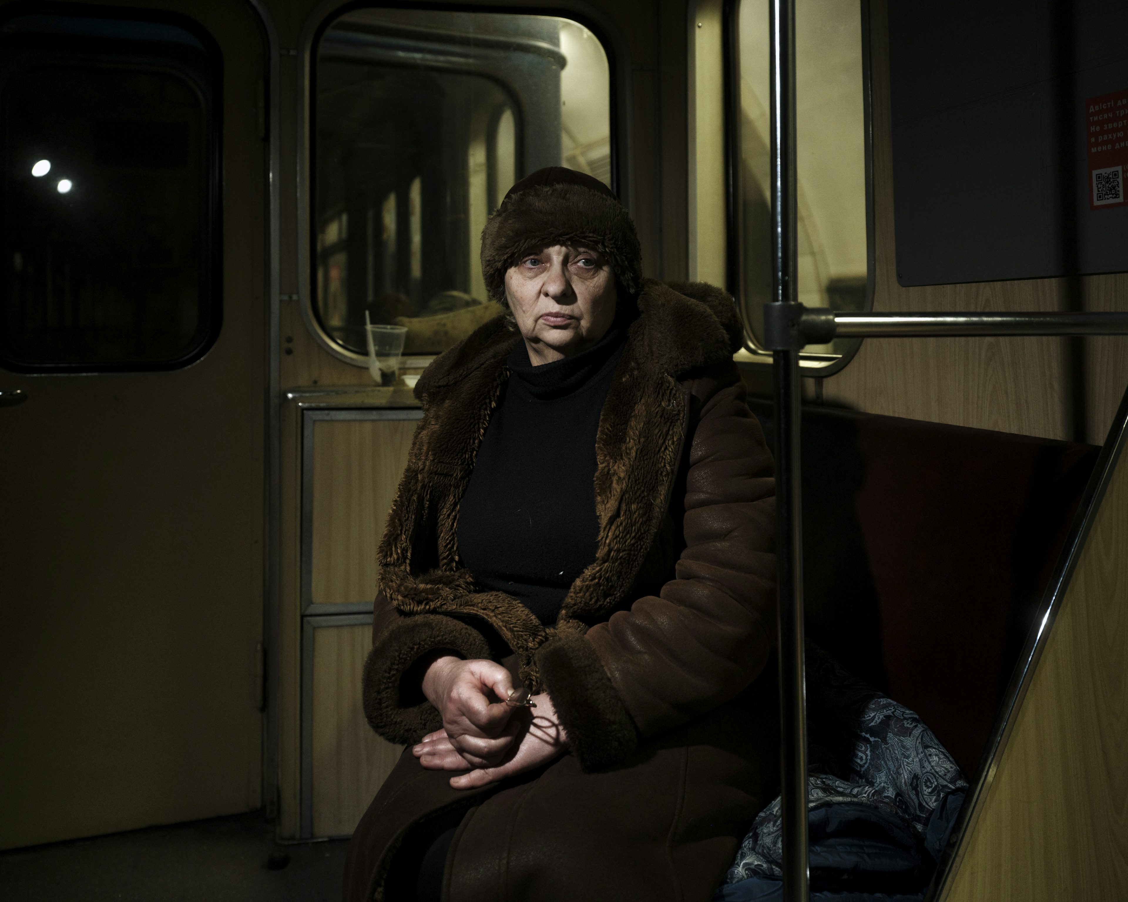 UKRAINE. Kyiv. 4 March 2022. A lady poses for a portrait inside a metro car parked in a tunnel, where she and her family sleep to shelter from the Russian army's mortar fire on the city. Photo by Lorenzo Meloni