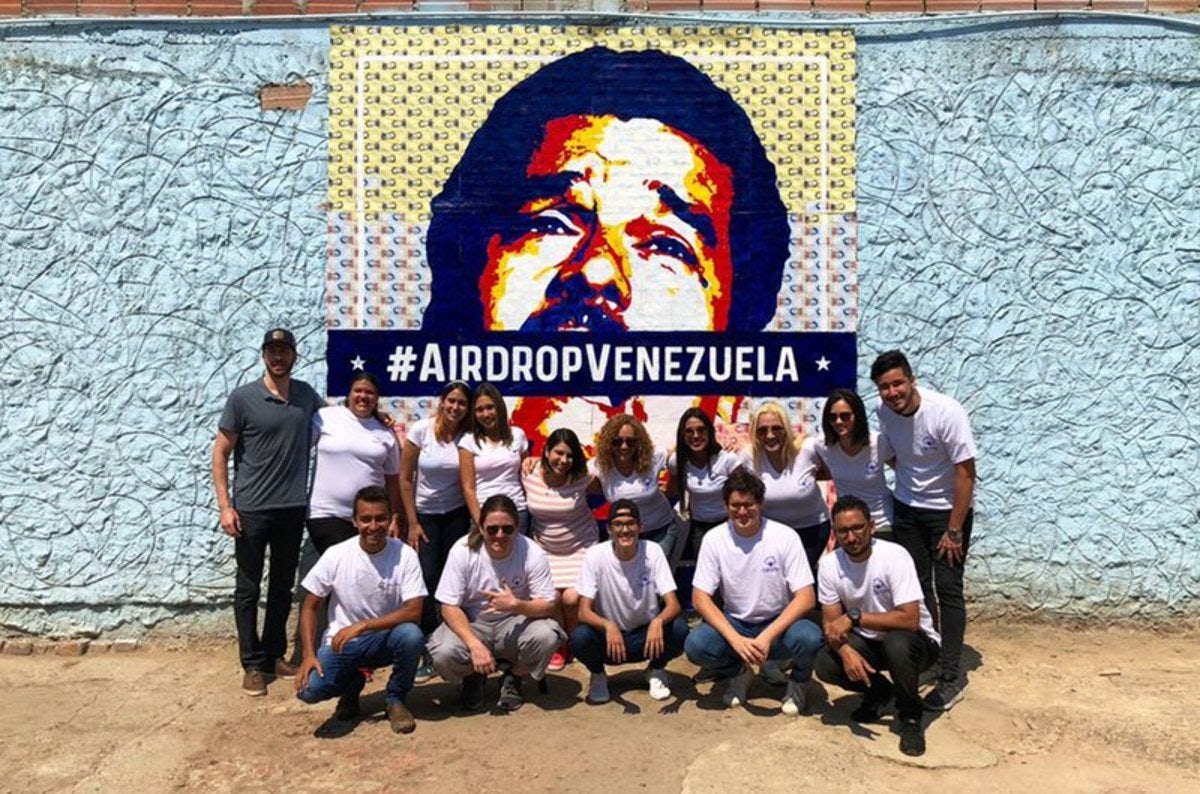 Cryptograffiti, left, along with the project team for #AirdropVenezuela, in front of his mural of disputed Columbian president, Nicolás Maduro. Image from: https://bitcoinmagazine.com/culture/crypto-art-auction-lets-venezuelans-dismantle-maduro-bolivar-bolivar
