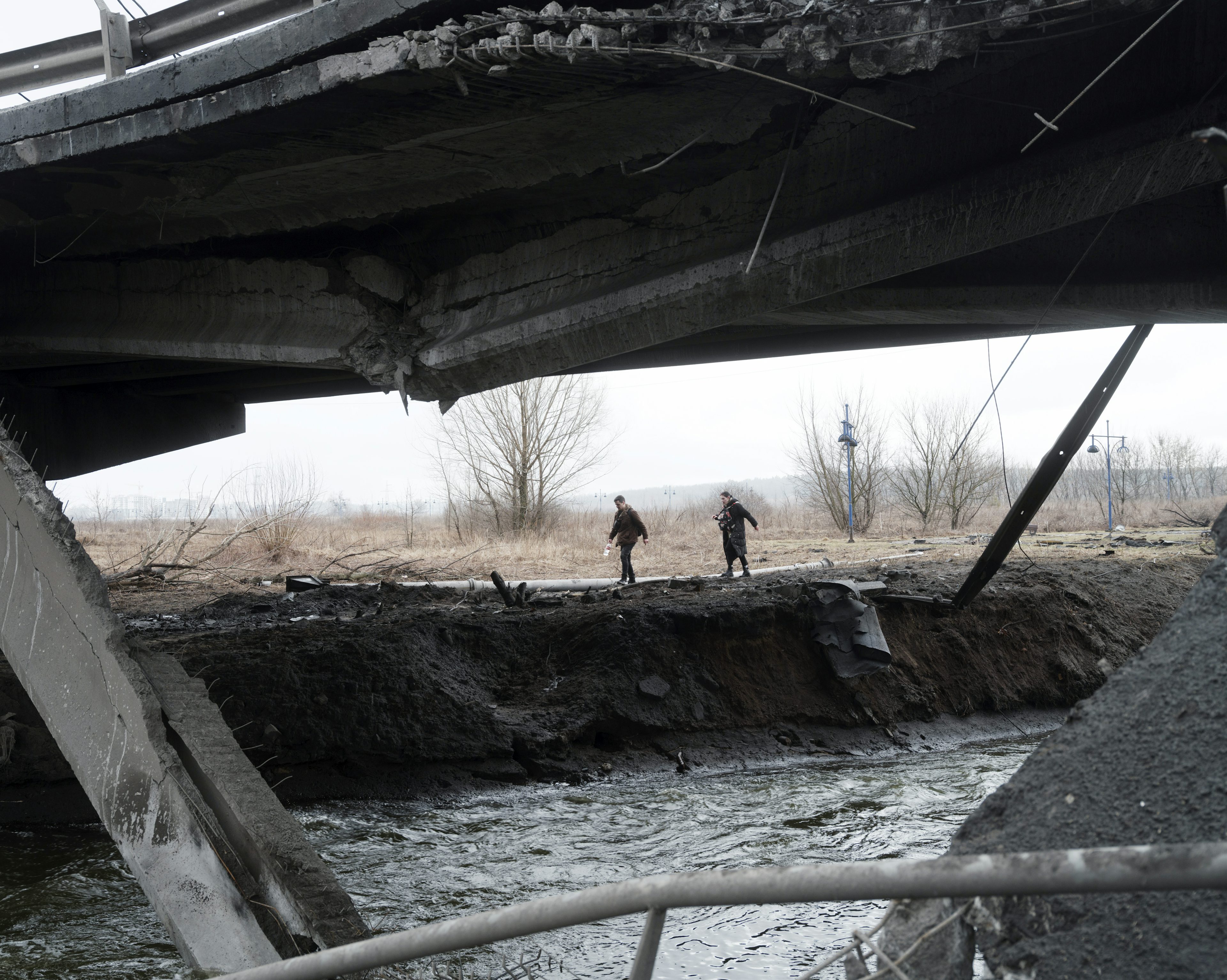 UKRAINE. Ivankiv. 3 March 2022.  Civilians pass around a bridge that the Ukrainian army had to blow up in order to stop the Russian advance. Photo Lorenzo Meloni