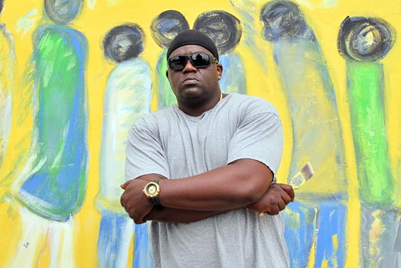Addonis Parker while Restoring Purvis Young’s “Everyday Life” Mural in Overtown, Miami