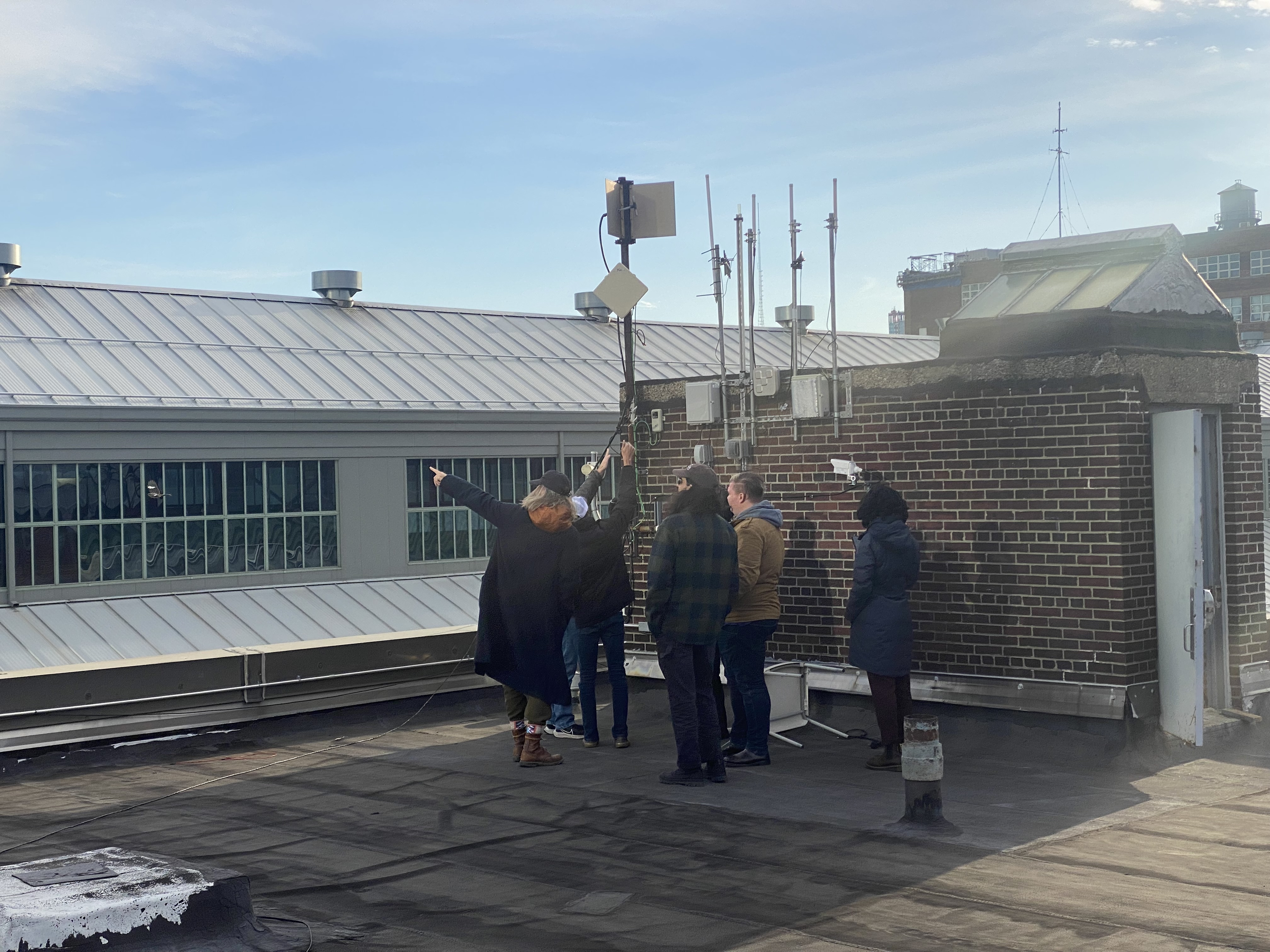 FOAM team members standing in front of FOAM Zone Anchor radio hardware on roof in Brooklyn Navy Yard Zone.